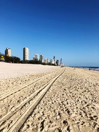 Scenic view of beach against clear blue sky