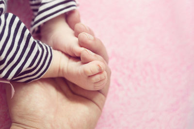 Close-up of mother holding baby hand