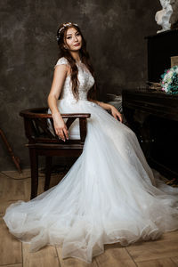 Portrait of bride wearing dress standing at home