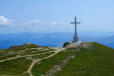 Cross on mountain against sky