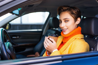 Portrait of young woman in car