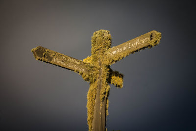 Low angle view of cross on wood against sky