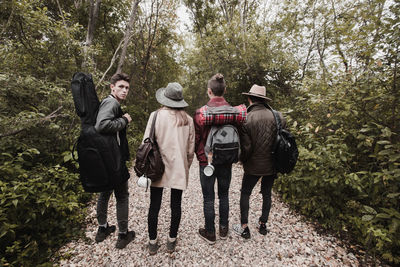 Rear view of people walking in forest