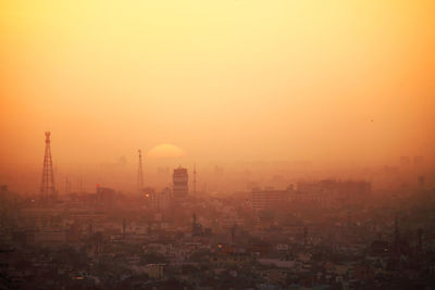 Aerial view of cityscape against clear sky during sunset