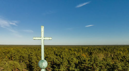 Cross on field against sky