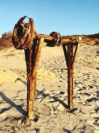 Close-up of rusty wood on field against clear sky