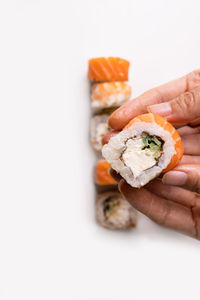 Hands cooking sushi with rice, salmon. japanese expert sushi chef rolling sushi.