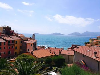 High angle view of town by sea against sky
