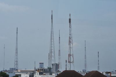 Cranes at construction site against sky in city