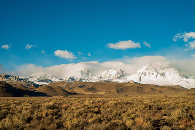 Scenic view of snowcapped mountains against blue sky