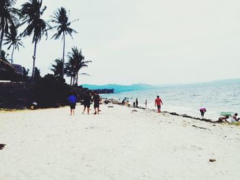 People at beach against sky