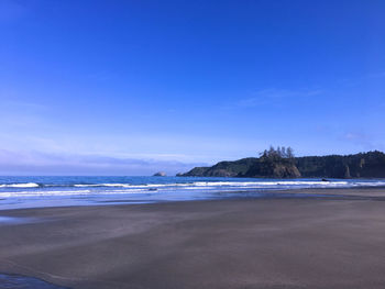 Scenic view of beach against blue sky