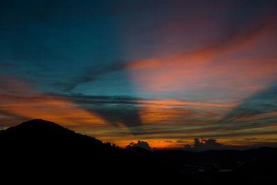 Scenic view of dramatic sky over silhouette landscape