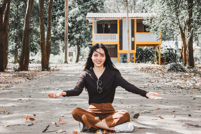 Portrait of smiling young woman sitting on land