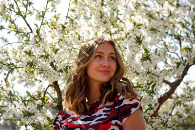 Portrait of a smiling young woman against plants