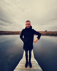 Full length of man standing by lake against sky