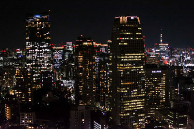 Illuminated buildings against sky at night