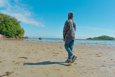 Rear view of woman standing at beach