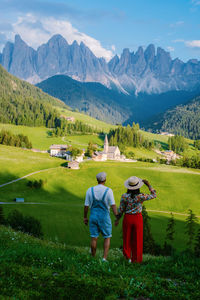 Rear view of men on field against mountains