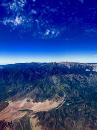 Scenic view of mountains against blue sky