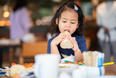 Girl eating food at restaurant