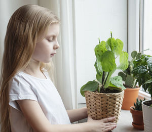 Midsection of woman holding potted plant