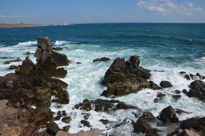 Rocks on sea shore against sky