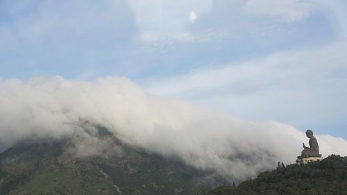 Man standing on mountain against sky