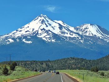 Scenic view of snowcapped mountains against blue sky