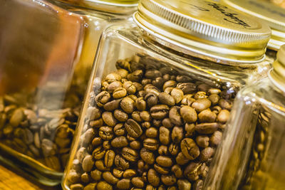 Close-up of roasted coffee beans in mason jar at table