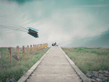 People on footpath by lake