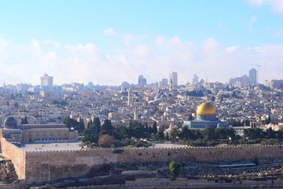 Aerial view of buildings in city against sky