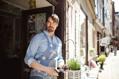 Portrait of smiling man standing against building
