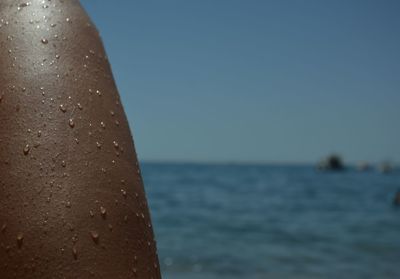 Close-up of woman on beach against clear sky