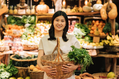 Portrait of smiling woman with fruits for sale