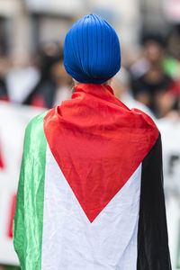 Rear view of woman with flag standing outdoors