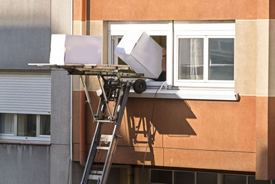 Moving company working with elevator in building exterior