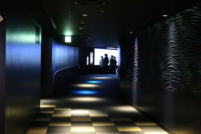 Silhouette of people walking in tunnel