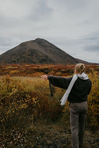 View from behind on woman overlooking the mountain during autumn in iceland