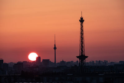 Silhouette communications towers against romantic sky at sunset