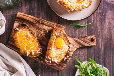 Bread baked with egg and cheese on a cutting board top view