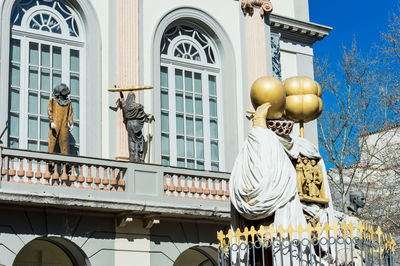 Low angle view of statue against building in city