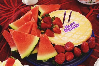 Close-up of birthday cake with watermelon and strawberries on table