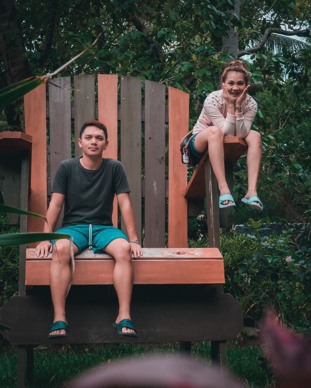 sitting, full length, real people, casual clothing, plant, leisure activity, front view, portrait, lifestyles, tree, people, looking at camera, seat, females, day, child, childhood, young adult, emotion, shorts, pre-adolescent child, teenager