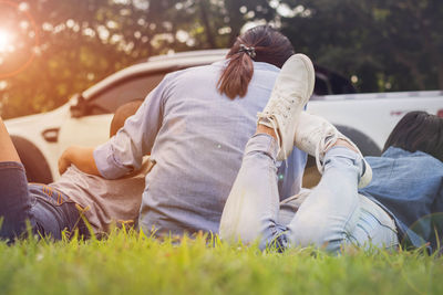 Rear view of women with sons sitting on field