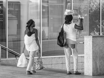 Rear view of people walking on glass window