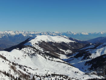 Scenic view of snowcapped mountains against clear blue sky