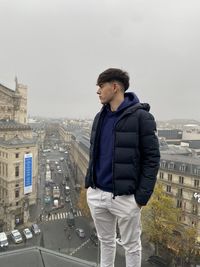 Portrait of young man standing against wall