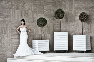 Portrait of woman wearing dress while standing in corridor of building