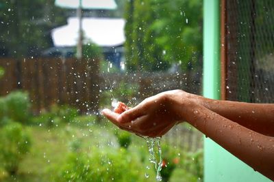 Close-up of rain falling on hands